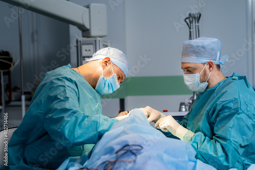 Process of surgery operation. Surgeons in operating room with surgery equipment. Medical background, selective focus.