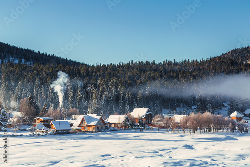 Winter landscape with the village of Iogach on the background of forested mountains. Altai Republic, Russia © vesta48