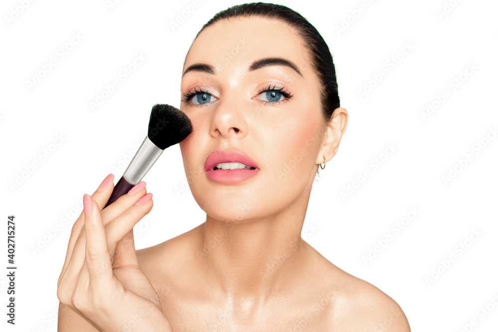 Portrait of a girl on a white background. Blush brush in hand near face.. Portrait of a girl on a white background. Blush brush in hand near face..