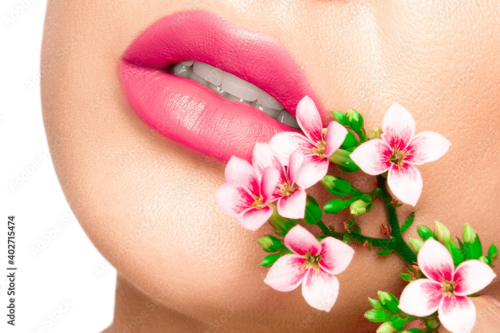 Girl lips with pink lipstick. There are pink flowers around the lips.. Girl lips with pink lipstick. There are pink flowers around the lips..