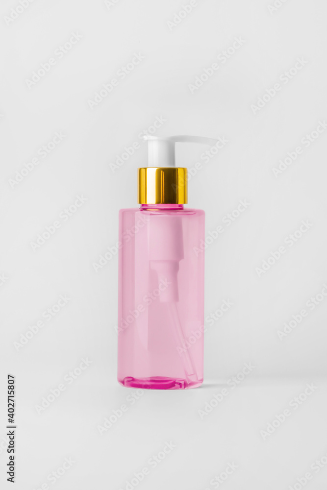Pink bottle with hydrophilic oil on a light background.. Pink bottle with hydrophilic oil on a light background..