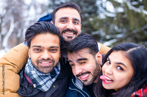 Photography arabic guys having great time on Christmas holidays taking selfie photo on phone