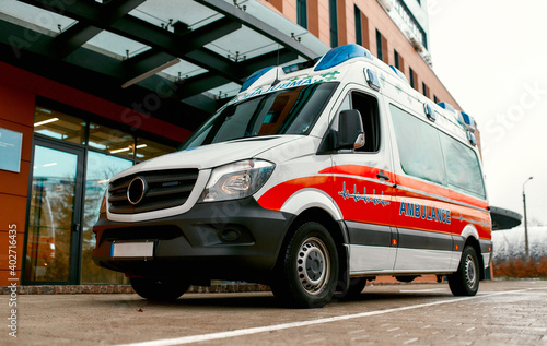 An ambulance stands outside a modern hospital. Doctor home call, health care concept.