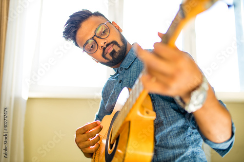 Giving guitar online lesson.Indian man is playing the guitar