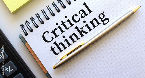 Notepad with text CRITICAL THINKING, next to it lies a calculator. Business concept.