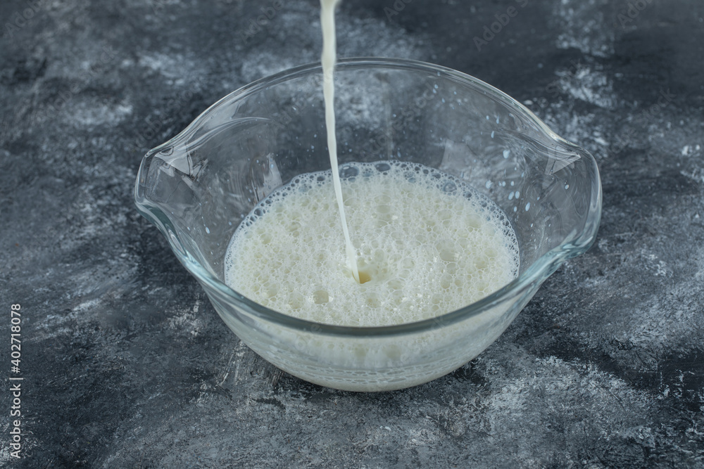 Splashing fresh milk into glass bowl Splashing fresh milk into glass bowl