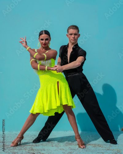 Latin Dance Couple Posing in Front of a Blue Background