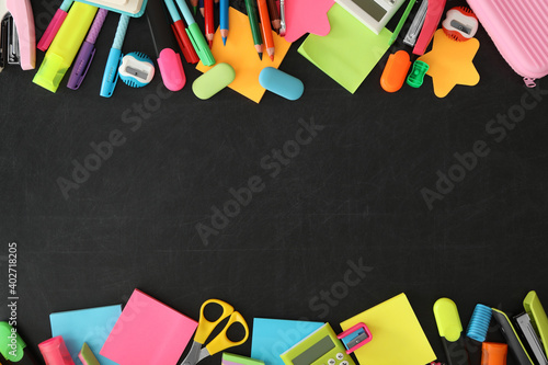 Fotografia Frame of different school stationery on blackboard, flat lay and space for text