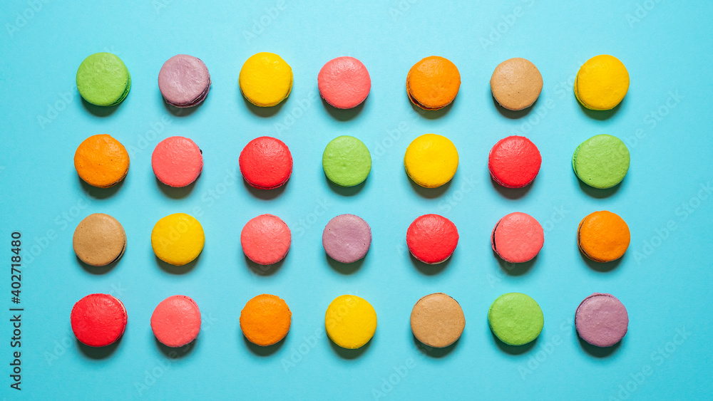 Homemade macarons flat lay. Multicolored macaroons top view on blue background Homemade macarons flat lay. Multicolored macaroons top view on blue background