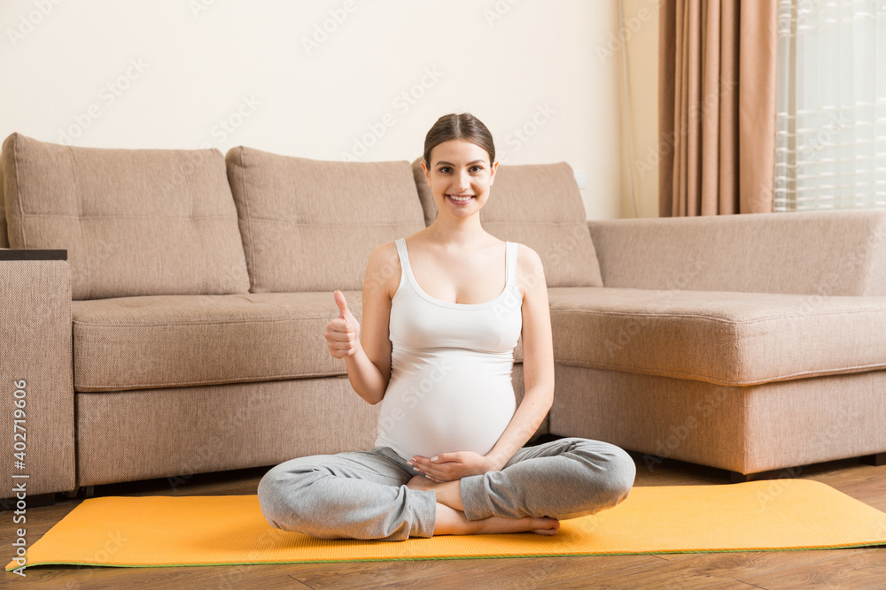 Portrait of young pregnant yoga model working at the home. Pregnancy Yoga and Fitness concept at coronavirus time