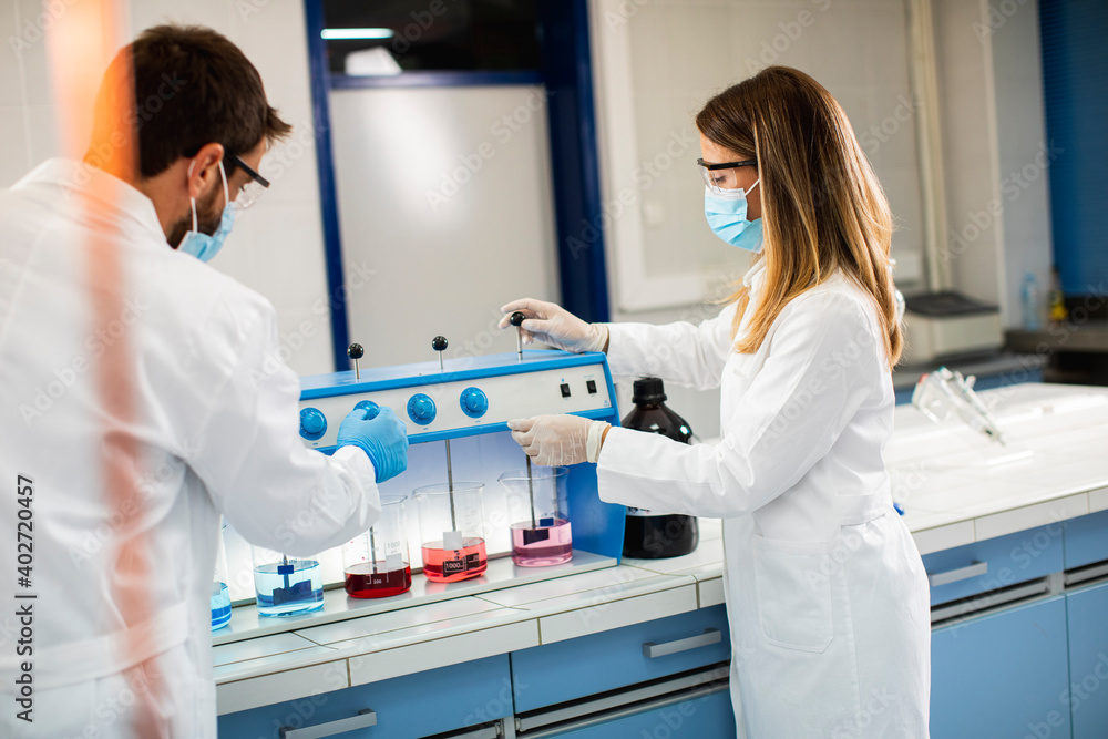 Group of young researchers analyzing chemical data in the flocculator at laboratory Group of young researchers analyzing chemical data in the flocculator at laboratory