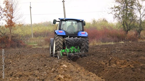 plowing in the field by a tractor with a trailed unit