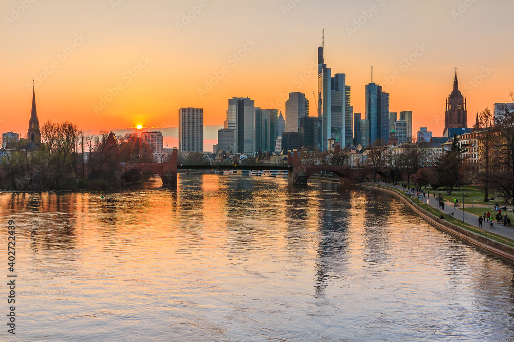 Frankfurt skyline in the evening at sunset. River Main reflections of the skyscrapers. Financial and business district in the center of the city. Park on the bank