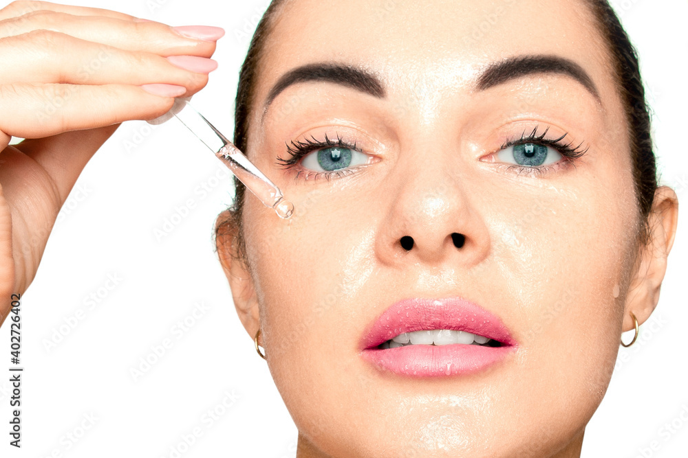 The girl applies hyaluronic acid to her face with a pipette..