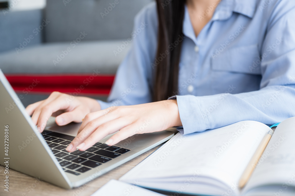 Business woman working from home by computer laptop. Close up and focus to keyboard and her hand. Business woman working from home by computer laptop. Close up and focus to keyboard and her hand.