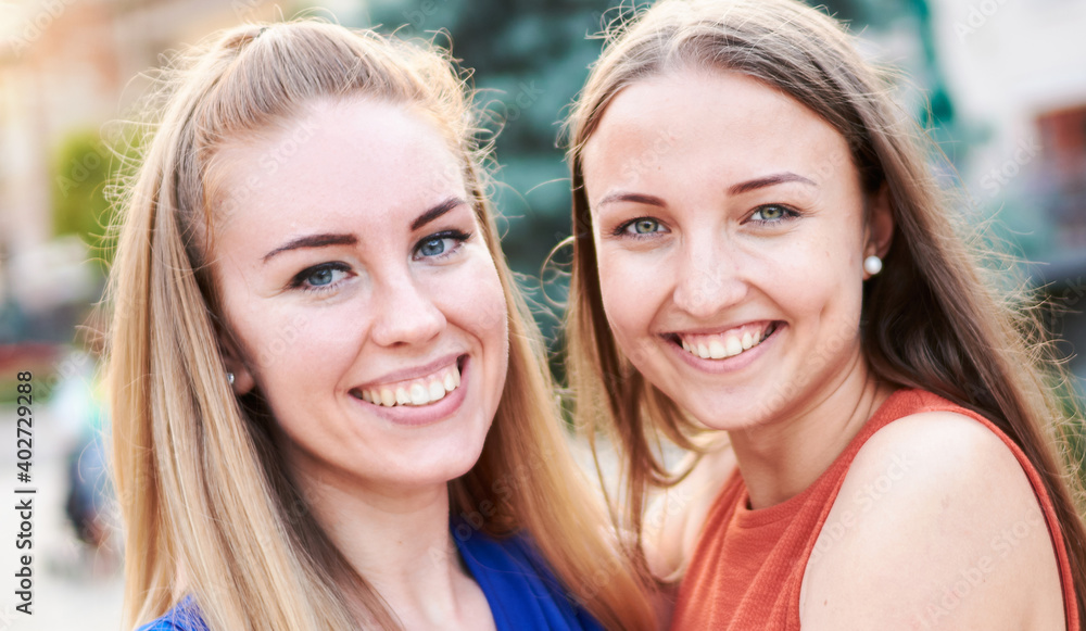 Obraz premium Young happy millennial girls having fun together - University students taking closeup selfie on the streets - Youth and friendship outdoor concept