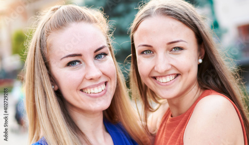 Young happy millennial girls having fun together - University students taking closeup selfie on the streets - Youth and friendship outdoor concept