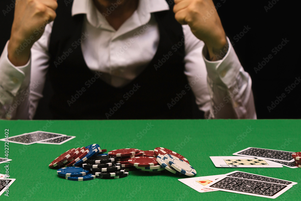 Person in a night casino playing poker, gambling money with chips. black background with copy space. concept of gambling, winning, losing, fun, wealth, triumph Person in a night casino playing poker, gambling money with chips. black background with copy space. concept of gambling, winning, losing, fun, wealth, triumph