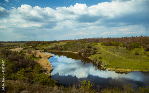 winding river bed, clouds are reflected in the water