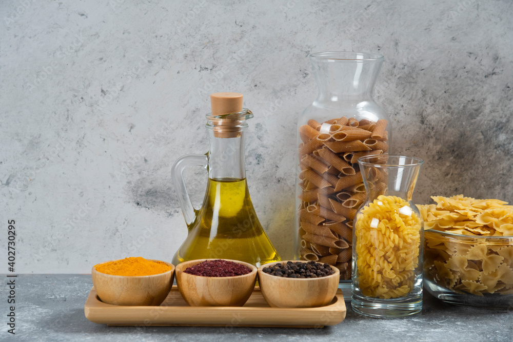 A glass bottle of oil with raw macaroni A glass bottle of oil with raw macaroni
