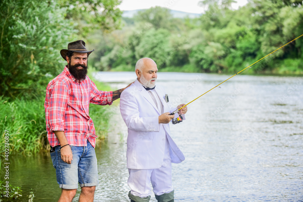 Fish with companion who can offer help in emergency. Fishing skills. Men friends relaxing nature background. Personal instructor. Bearded man and elegant businessman fish together. Learn to fish
