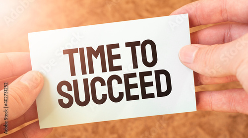 Time to succeed word inscription on white card paper sheet in hands of a businessman. recap concept. red and white paper