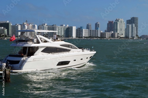 Luxury motor yacht on Biscayne Bay with Miami Beach luxury condo building skyline in the background. © Wimbledon