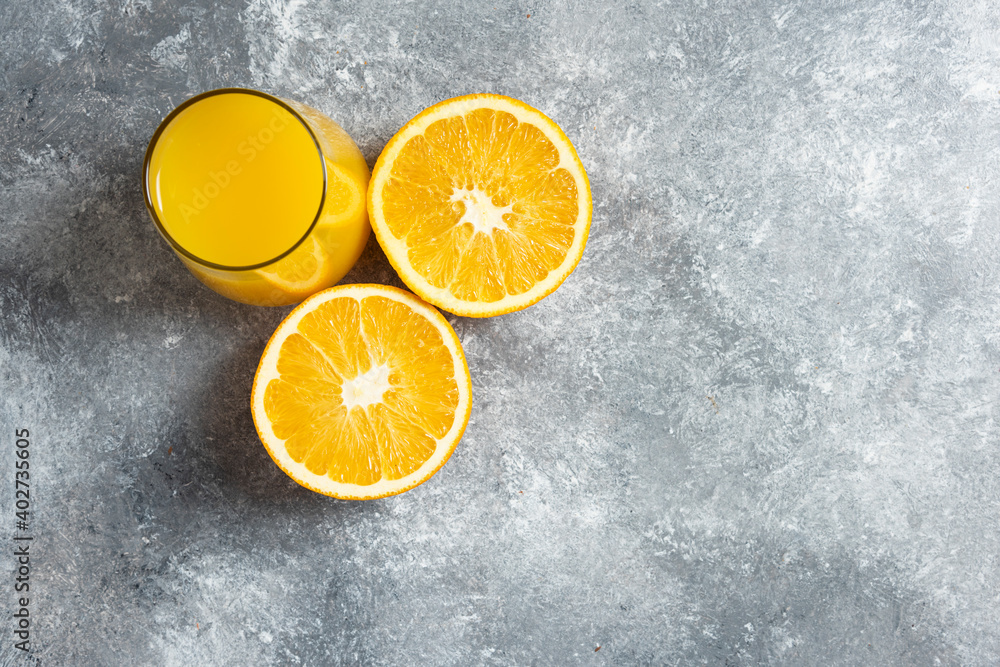 A glass cup of orange juice and slices of orange A glass cup of orange juice and slices of orange
