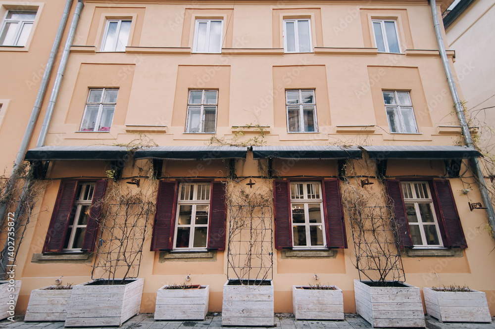 Many old windows with shutters on the facade of a house in Lviv, Ukraine.