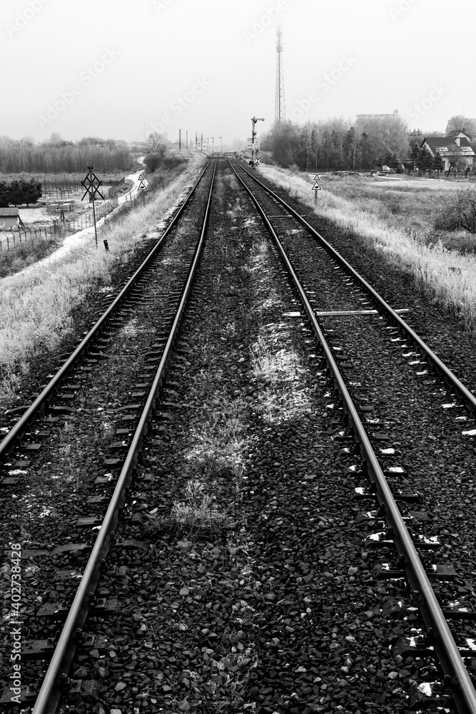 Two railroad tracks leading through the fields. Railway traction near the railway station.