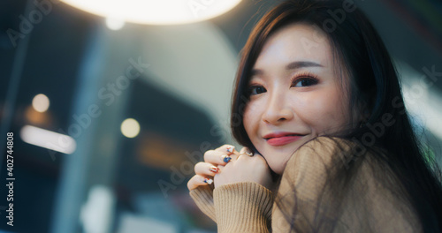 Beautiful young Asian woman smile happily, look at camera, with copy space. People casual leisure, happiness, cafe lifestyle, or cosmetic skincare concept. Captured on RED Komodo 6K