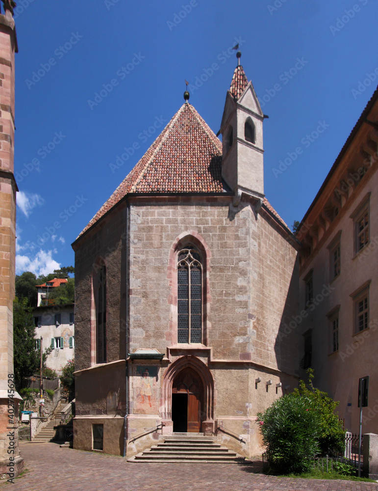 Octagonal gothic chapel of St Barbara entrance door and pointed window arch in the old medieval town of Merano in South Tyrol, Italy