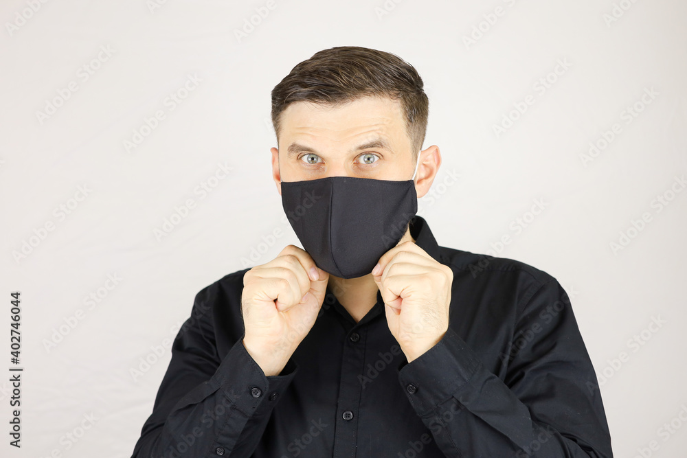 the man wears a black medical mask on a white background the man wears a black medical mask on a white background