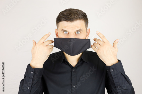the man wears a black medical mask on a white background