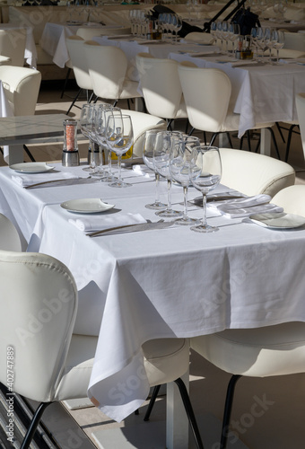 Before lunch time, empty cafes with served tables and tablecloths waiting for guests in Saint-Tropez, Provence, France