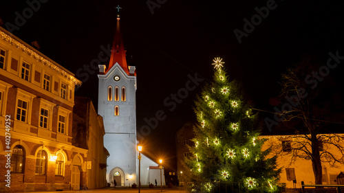 Ancient St. John`s Church at Night Located in Cesis, Latvia. Cesis Medieval Castle and City in Background. Cristmas Time Night Shot.