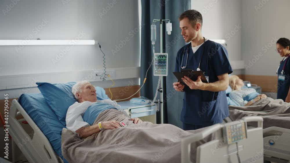 Hospital Ward: Friendly Male Nurse Talks with Elderly Patient Resting in Bed. Doctor Uses Tablet Computer, Does Checkup. Old Man Fully Recovering after Successful Surgery. Modern Bright Clinic Hospital Ward: Friendly Male Nurse Talks with Elderly Patient Resting in Bed. Doctor Uses Tablet Computer, Does Checkup. Old Man Fully Recovering after Successful Surgery. Modern Bright Clinic