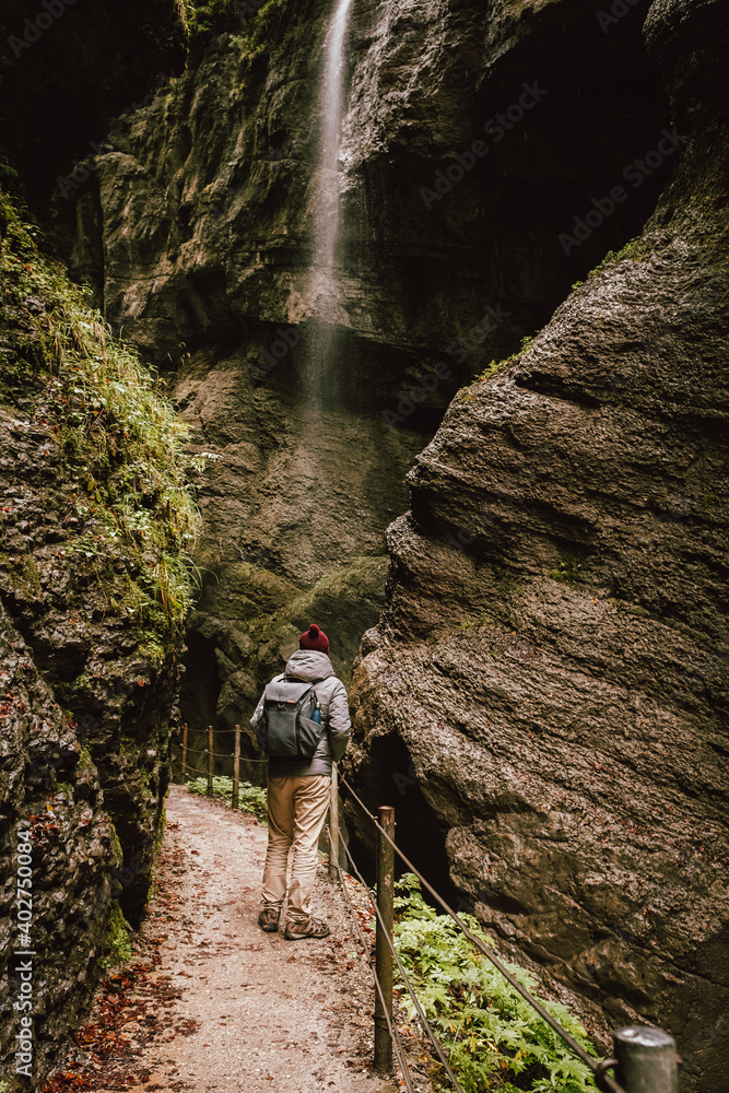Man standing crossing a waterfall path with his bag in Germany