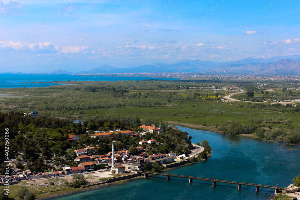Beautiful cityscape from Skodra, Shkodër, Albania. Scenic view of river, bridge and Shkodra cityscape, from Rozafa Castle with cloudy sky. 