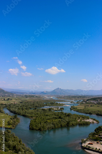 Beautiful cityscape from Skodra  Shkod  r  Albania. Scenic view of river and Shkodra cityscape from Rozafa Castle with cloudy sky. 