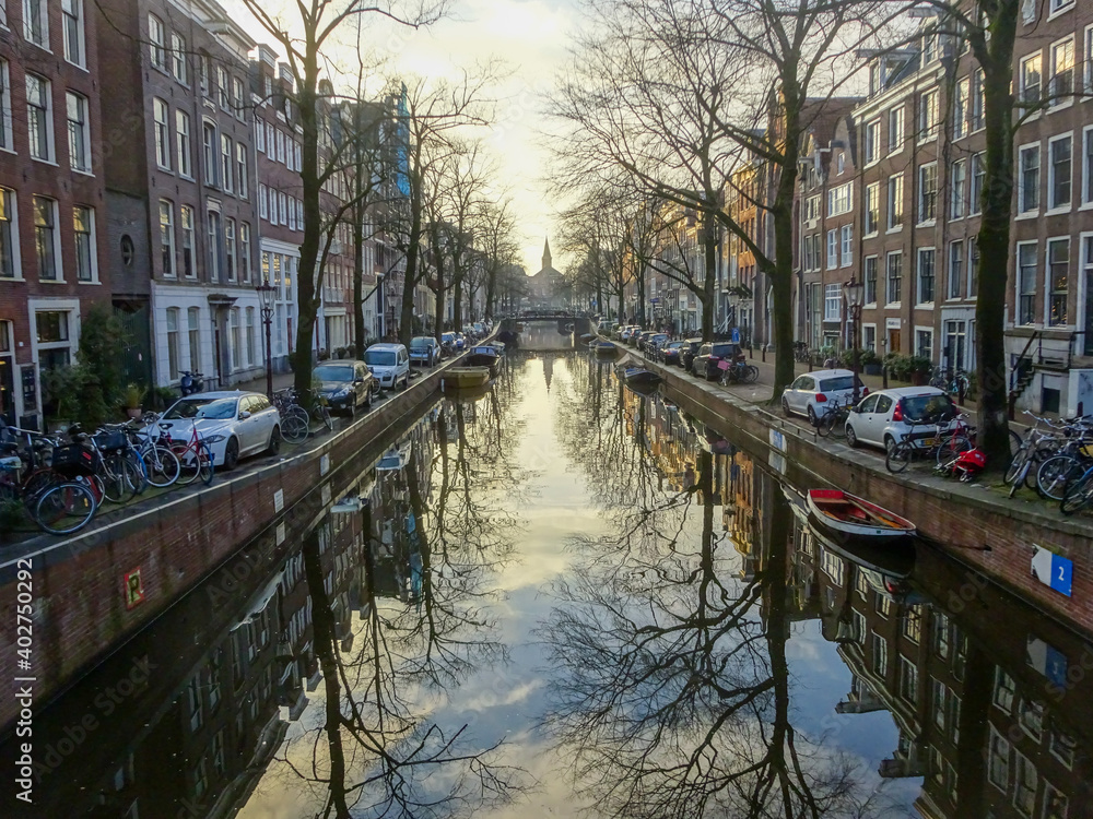 Amsterdam canal with beautiful historical houses with reflection in the water during winter, Amsterdam, Netherlands
