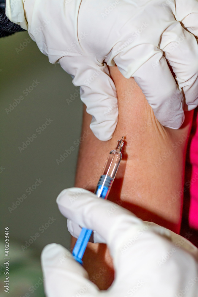 Covid-19: Nurse's hand in white injects a vaccine against Covid-19 (SARS-COV-2) into the arm of a child. Covid-19: Nurse's hand in white injects a vaccine against Covid-19 (SARS-COV-2) into the arm of a child.