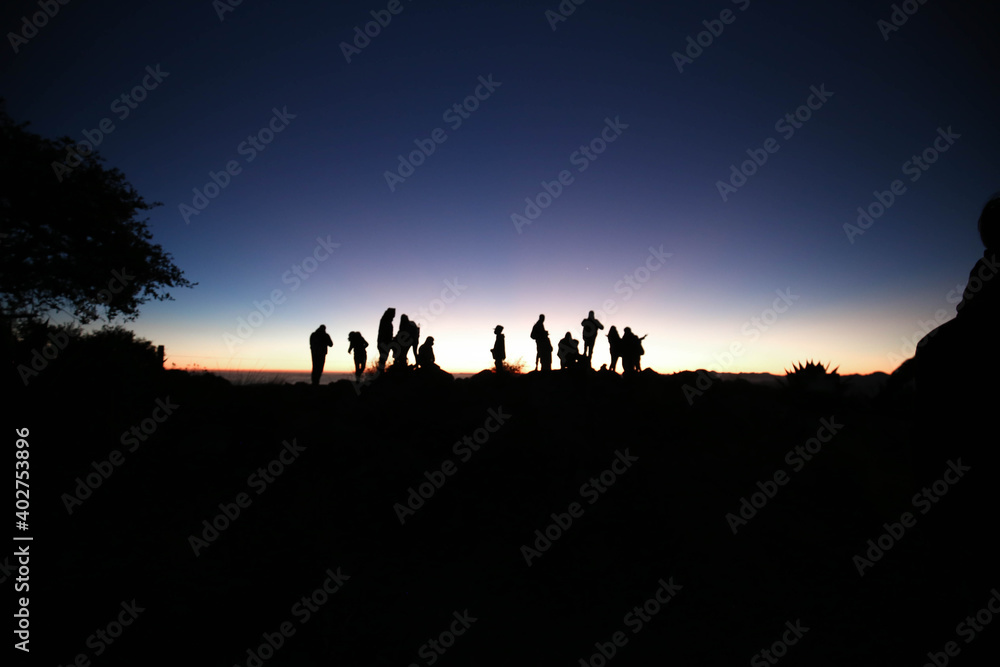 silhouette of people and Epic and colorful sunrise in the to mountains