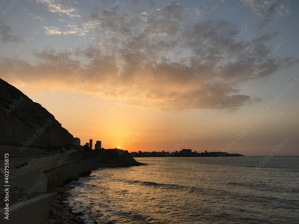 beautiful and colorful sunrise in the beach with some clouds