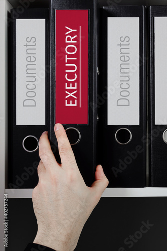 Executory. Folder with label on the shelf of a lawyer. Red label with text in focus. photo