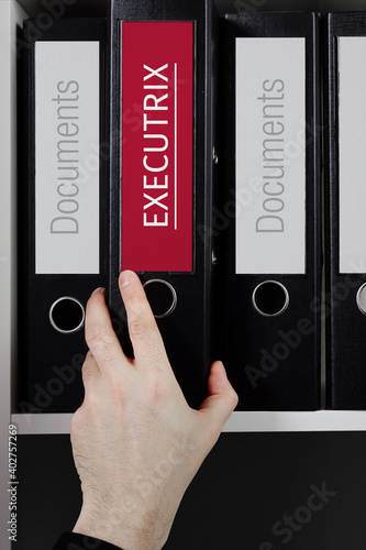 Executrix. Folder with label on the shelf of a lawyer. Red label with text in focus. photo