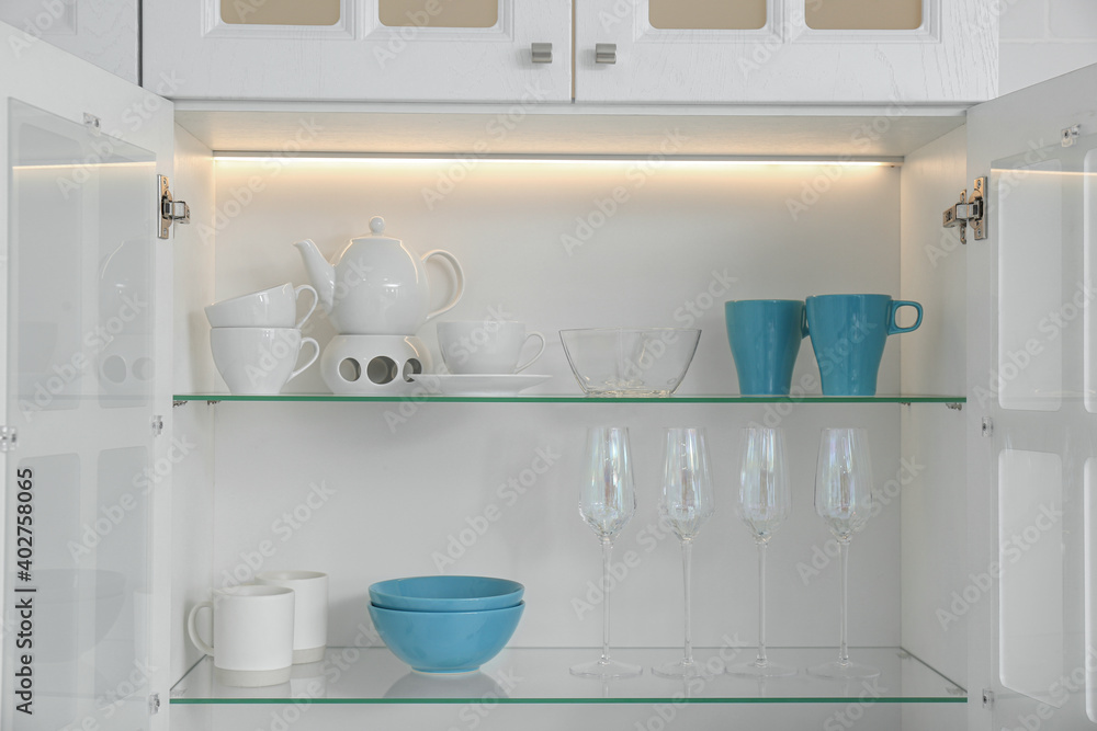 Open kitchen cabinet with different clean dishware Open kitchen cabinet with different clean dishware