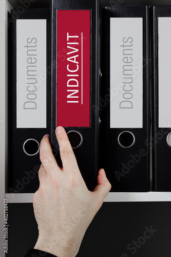 Indicavit. Folder with label on the shelf of a lawyer. Red label with text in focus. photo