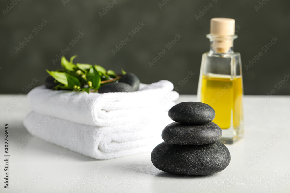 Spa stones, towels and oil on white table Spa stones, towels and oil on white table