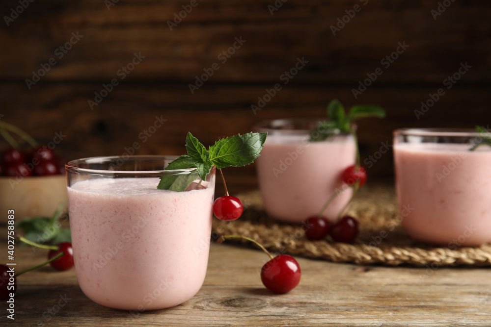 Tasty fresh milk shake with cherries on wooden table. Space for text Tasty fresh milk shake with cherries on wooden table. Space for text